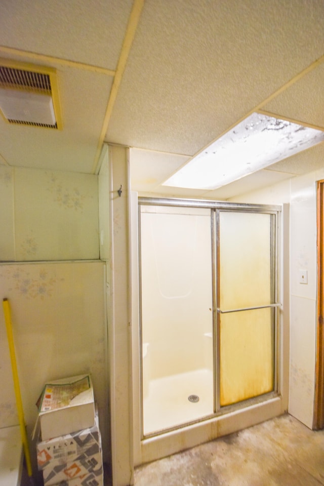 bathroom with an enclosed shower and concrete floors