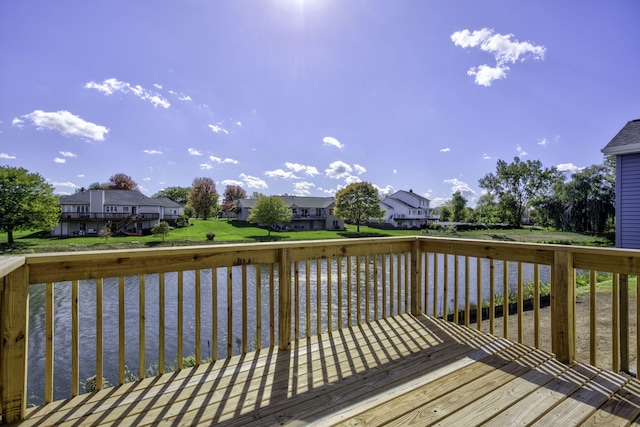 wooden deck with a yard and a water view