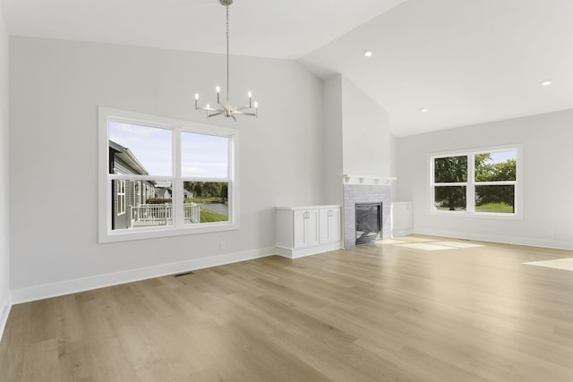 unfurnished living room with lofted ceiling, light hardwood / wood-style floors, and a wealth of natural light