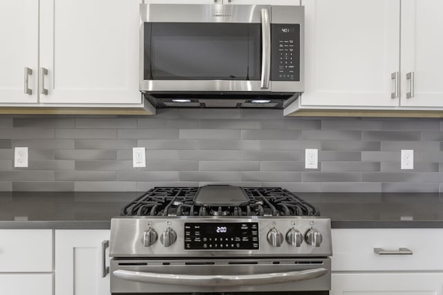 kitchen with stainless steel appliances, backsplash, and white cabinetry