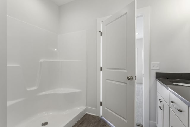 bathroom with walk in shower, hardwood / wood-style flooring, and vanity