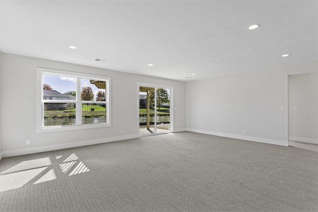 carpeted spare room with a water view