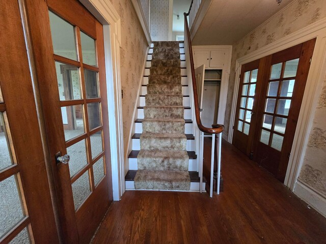 stairs featuring french doors and hardwood / wood-style flooring