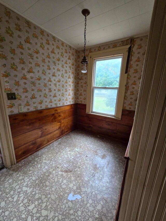 unfurnished dining area featuring wood walls