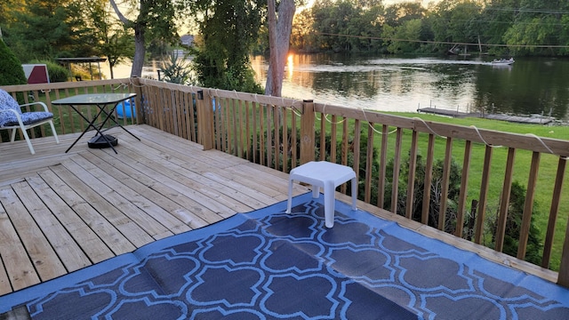 wooden deck with a yard and a water view