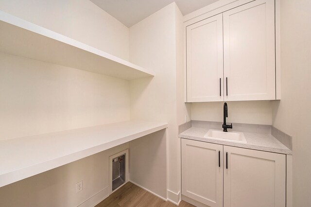 washroom with cabinets, sink, and wood-type flooring