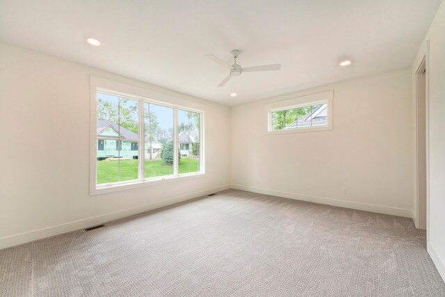 carpeted spare room with ceiling fan