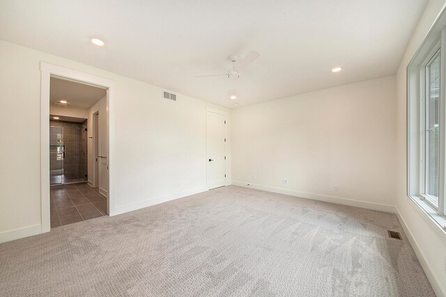 spare room with dark carpet and ceiling fan