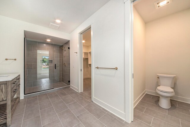 bathroom featuring toilet, an enclosed shower, vanity, and tile patterned floors