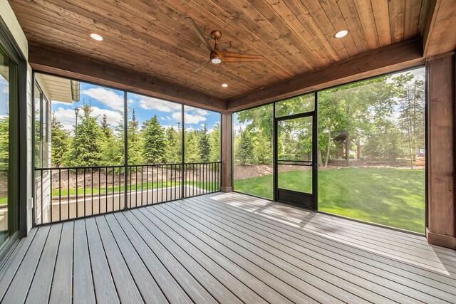 unfurnished sunroom with wood ceiling, a healthy amount of sunlight, and ceiling fan