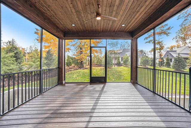 unfurnished sunroom featuring wood ceiling and ceiling fan