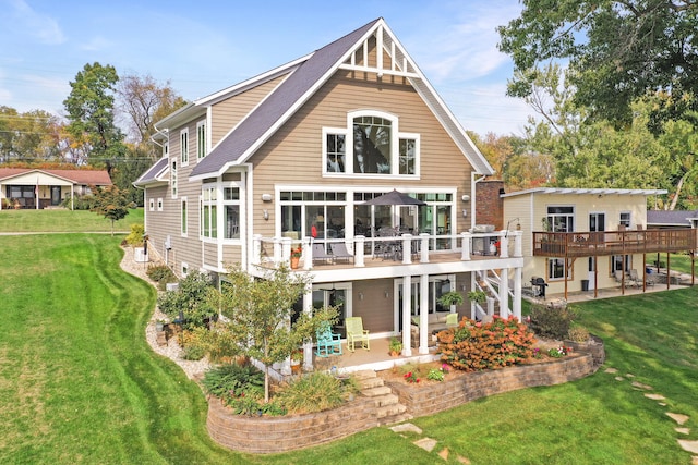 back of property featuring a patio area, a deck, and a lawn