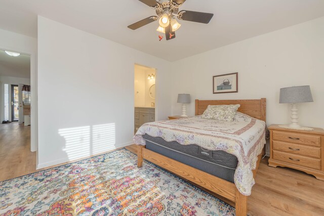 bedroom with ensuite bathroom, ceiling fan, and light wood-type flooring