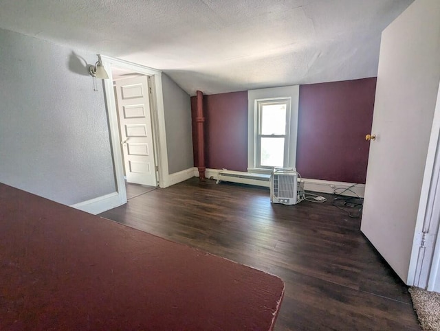 bonus room featuring a textured ceiling, a baseboard radiator, vaulted ceiling, and dark hardwood / wood-style flooring