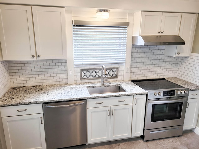 kitchen featuring sink, backsplash, white cabinetry, stainless steel appliances, and light stone countertops