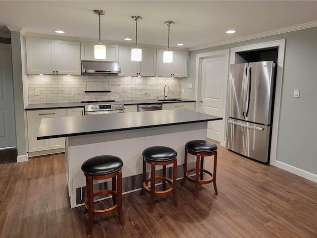 kitchen featuring stainless steel appliances, dark hardwood / wood-style flooring, hanging light fixtures, white cabinetry, and range hood