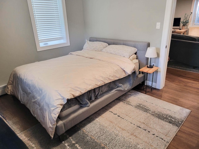 bedroom with dark hardwood / wood-style floors