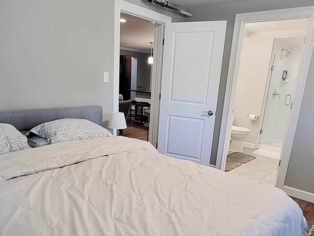 bedroom with wood-type flooring and ensuite bathroom