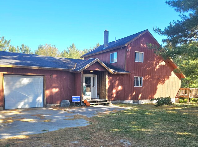 rear view of property with a yard and a garage