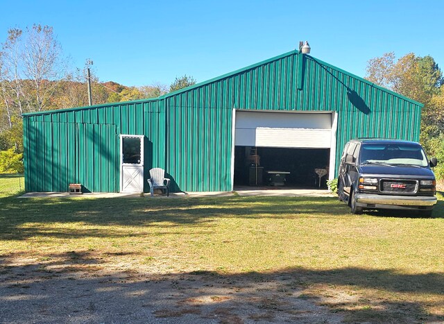 view of outdoor structure featuring a garage and a lawn