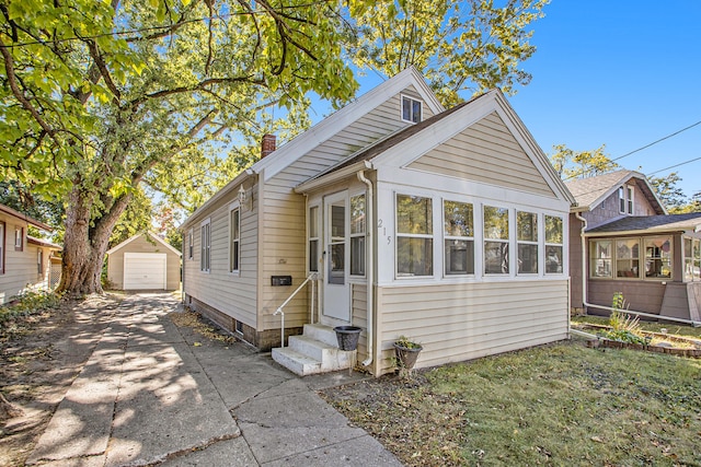 bungalow-style home featuring an outbuilding, a sunroom, and a garage