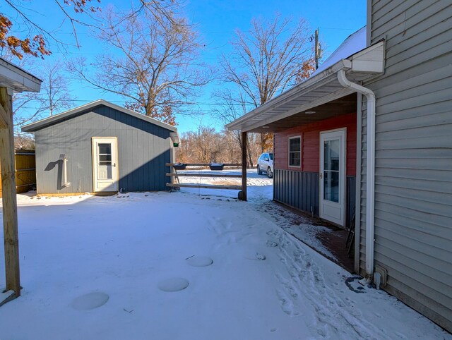 yard covered in snow featuring an outdoor structure