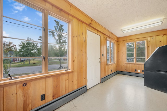 unfurnished sunroom featuring a baseboard heating unit