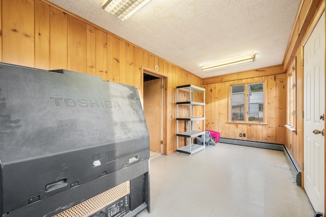 miscellaneous room featuring a textured ceiling and wooden walls