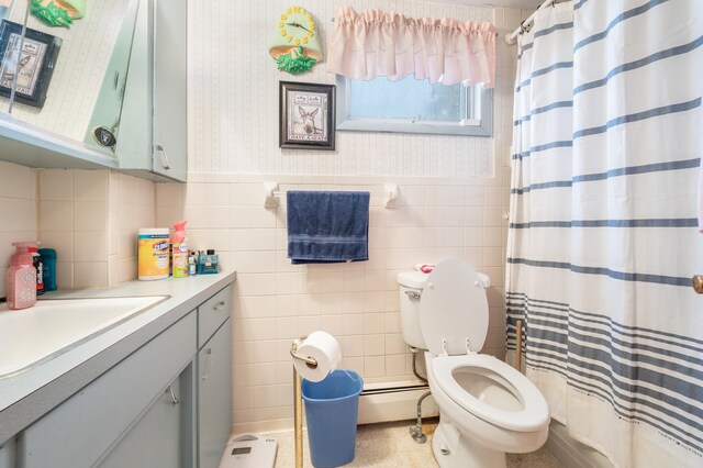 bathroom with vanity, curtained shower, a baseboard radiator, tile walls, and toilet