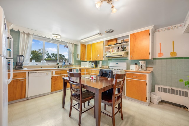 kitchen with white appliances, sink, and radiator