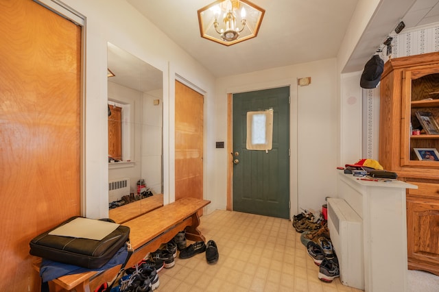 mudroom featuring radiator and a notable chandelier