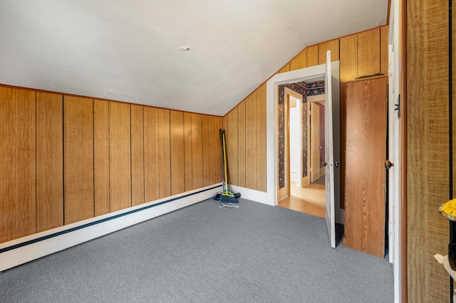 additional living space featuring carpet, vaulted ceiling, a baseboard heating unit, and wooden walls