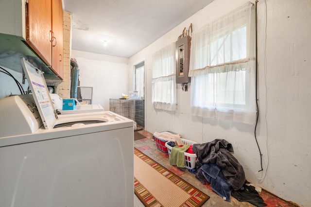 laundry room with electric panel, washing machine and clothes dryer, and cabinets