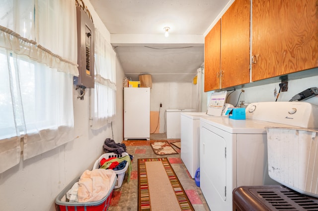 washroom featuring washing machine and dryer, electric panel, and cabinets