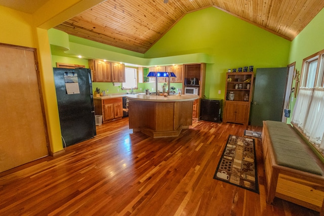 kitchen featuring wood ceiling, a kitchen island, high vaulted ceiling, black refrigerator, and dark hardwood / wood-style flooring