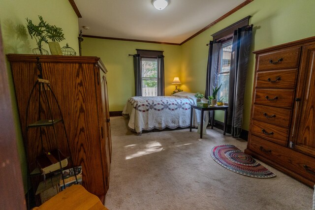 bedroom with ornamental molding and light colored carpet