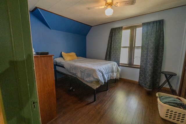 bedroom featuring ceiling fan, dark wood-type flooring, and vaulted ceiling