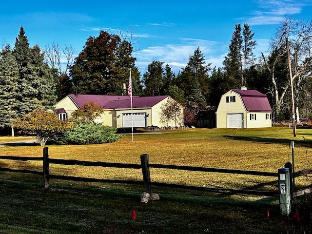 view of front of house featuring a front yard, a garage, and an outbuilding