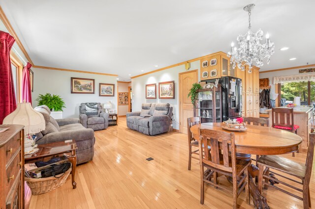 dining room featuring light wood-type flooring, a chandelier, and ornamental molding