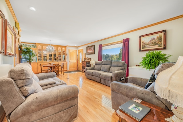 living room featuring a notable chandelier, light hardwood / wood-style flooring, and ornamental molding