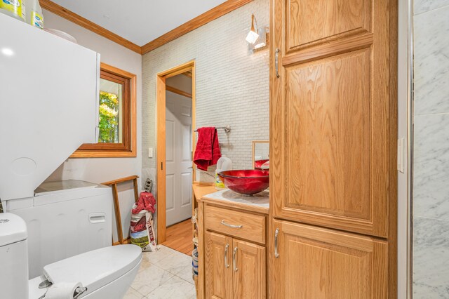 bathroom featuring ornamental molding, vanity, and toilet