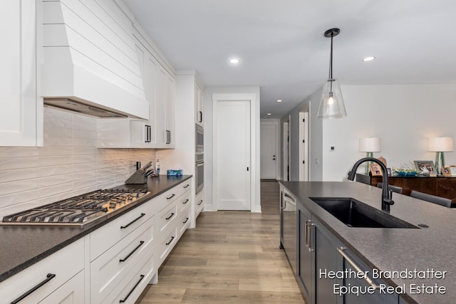 kitchen featuring wood-type flooring, white cabinets, and premium range hood