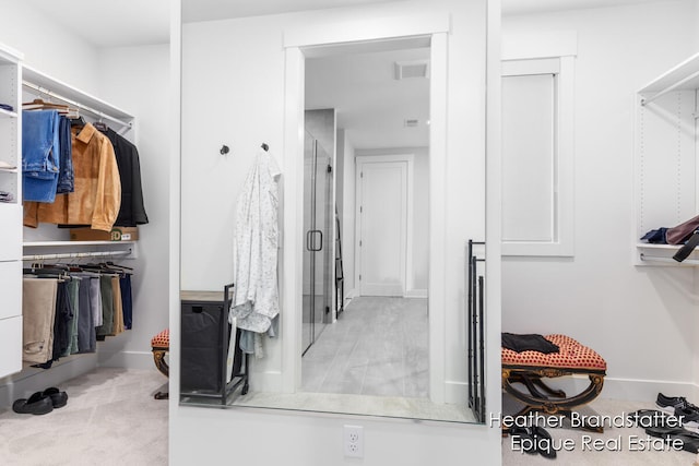 walk in closet featuring light colored carpet