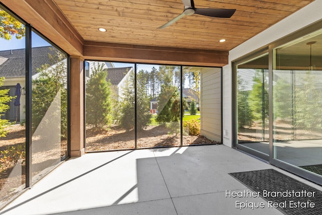 unfurnished sunroom featuring wooden ceiling and ceiling fan