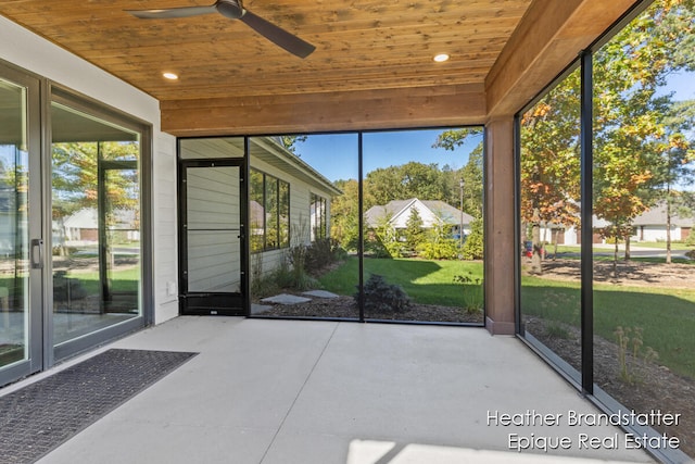 unfurnished sunroom featuring wood ceiling and ceiling fan