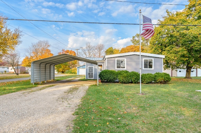 view of front of house featuring a front yard, an outbuilding, a garage, and a carport