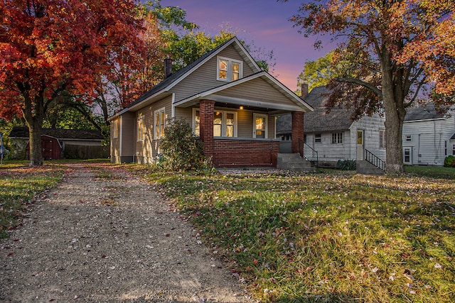 view of front facade with a storage shed and a porch