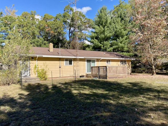 back of property with a wooden deck and a yard