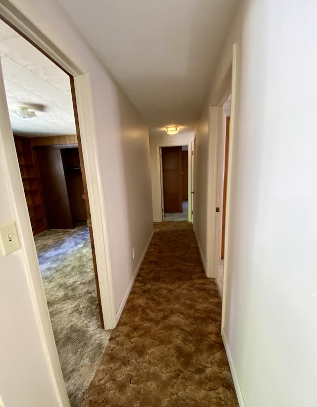 corridor with dark colored carpet