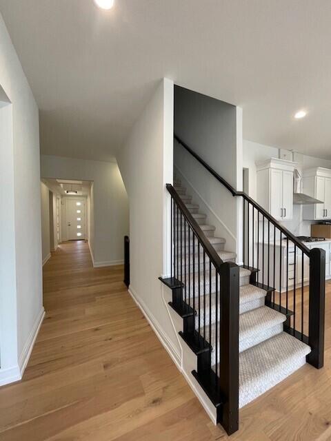 staircase with hardwood / wood-style flooring